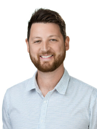 Head and shoulders image of Luke Webster, smiling, wearing a light blue shirt